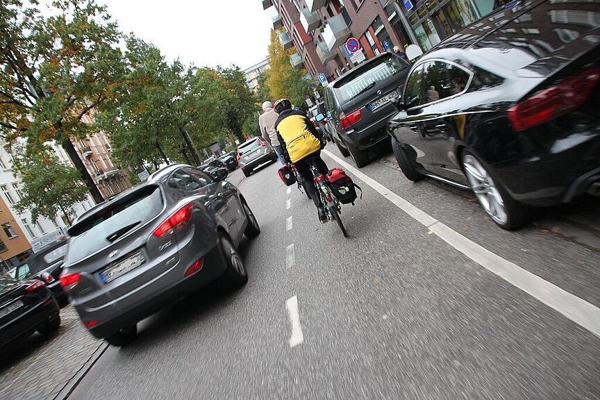 Ein Radfahrer auf einem Schutzstreifen wird mit weniger als 1,5 m Abstand überholt.